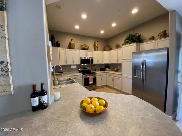 a kitchen with granite countertop a white cabinets and stainless steel appliances