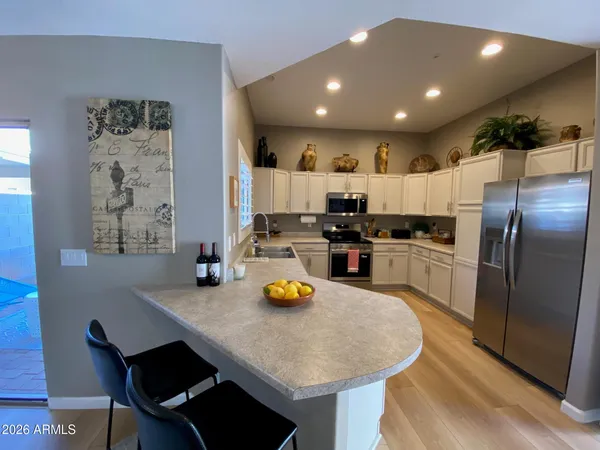 a kitchen with stainless steel appliances granite countertop a sink a stove a refrigerator cabinets and living room view