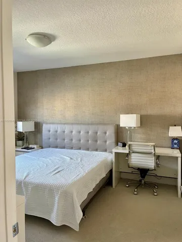 a bedroom with a bed and a night stand