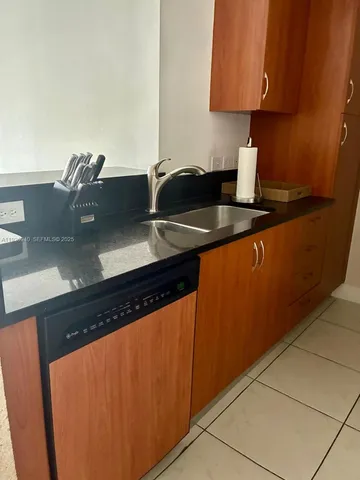 a kitchen with granite countertop a sink and cabinets