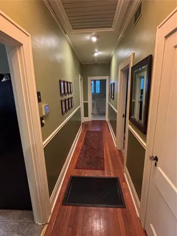 a view of a hallway with wooden floor and stairs