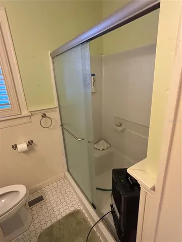 a bathroom with a granite countertop shower and a toilet