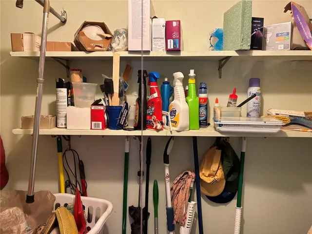 a utility room with lots of clutter and cabinets