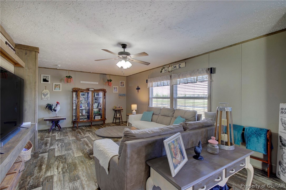 3029 Carsley Road Dendron, VA 23839 - Photo 18 of 26 Living room featuring dark hardwood / wood-style flooring, a textured ceiling, and ceiling fan