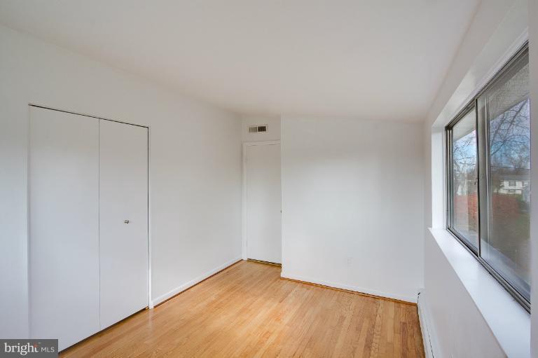 3619 Rusty Rock Road Randallstown, MD 21133 - Photo 21 of 30 a view of an empty room with wooden floor and a window