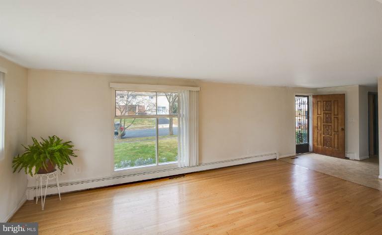 3619 Rusty Rock Road Randallstown, MD 21133 - Photo 4 of 30 a view of an empty room with glass door and wooden floor