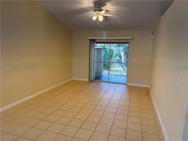 a view of an empty room and chandelier fan