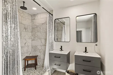 a bathroom with a double vanity sink mirror and shower