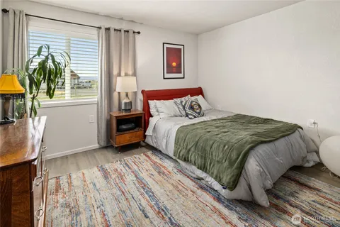 a bed sitting in a bedroom next to a window