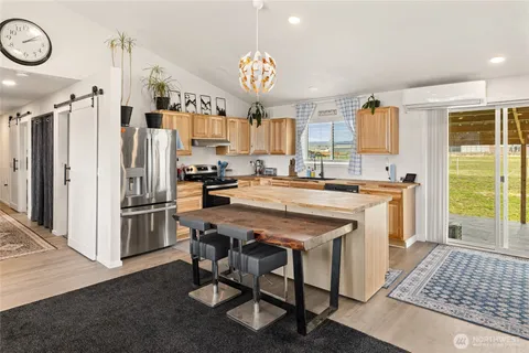 a kitchen with a stove a refrigerator and a dining table