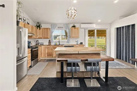 a kitchen with stainless steel appliances granite countertop a stove a sink dishwasher and a refrigerator with wooden floor