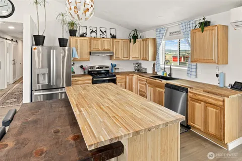 a kitchen with stainless steel appliances a stove a sink dishwasher and wooden cabinets