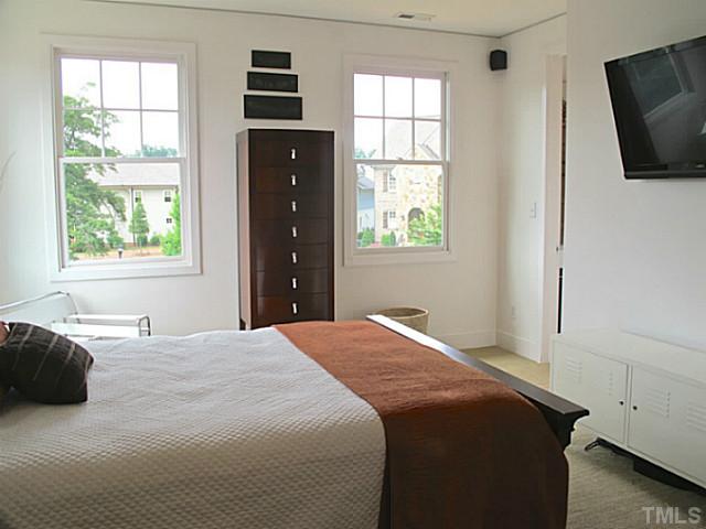 2108 Blue Oak Terrace Raleigh, NC 27608 - Photo 17 of 25 a bedroom with a bed and a flat tv screen on dresser