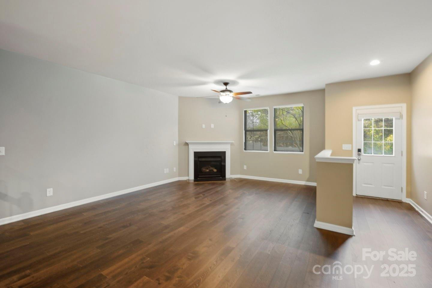 8988 Lanark Lane Fort Mill, SC 29707 - Photo 5 of 43 an empty room with wooden floor fireplace and windows