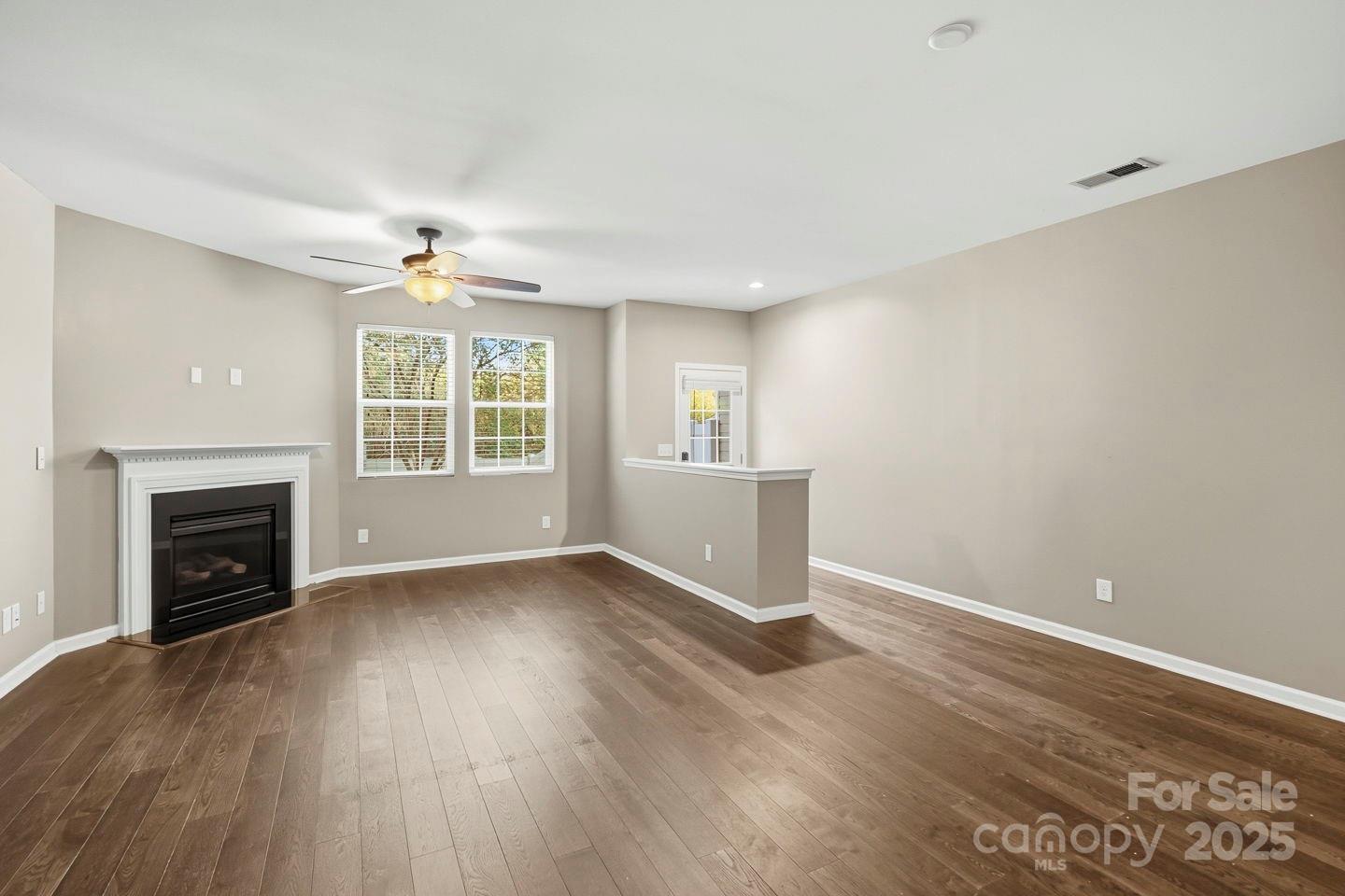 8988 Lanark Lane Fort Mill, SC 29707 - Photo 8 of 43 an empty room with windows fireplace and wooden floor