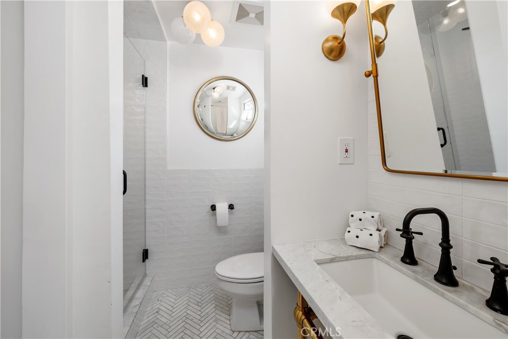 5306 Norwich Avenue Sherman Oaks, CA 91411 - Photo 22 of 43 a bathroom with a sink a toilet and a mirror