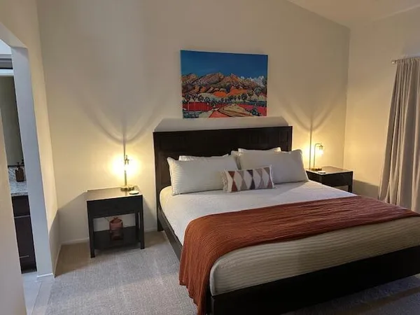 a bedroom with a bed and a painting on the wall