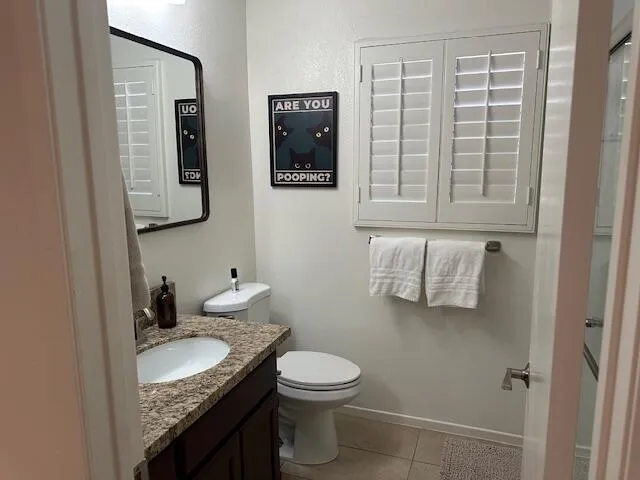 a bathroom with a granite countertop sink toilet and mirror