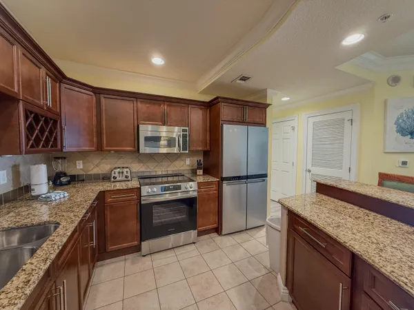 a kitchen with stainless steel appliances granite countertop a stove refrigerator sink and microwave