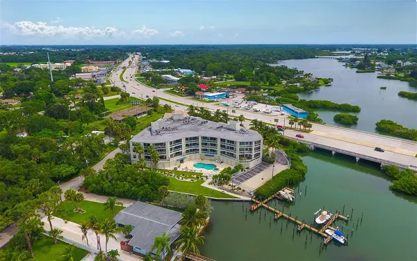 an aerial view of residential houses with outdoor space and lake view