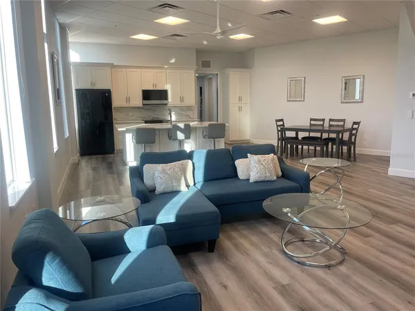 a living room with stainless steel appliances kitchen island granite countertop furniture and a kitchen view