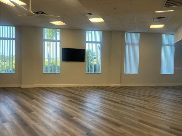 a room with furniture pool table flat screen tv and windows