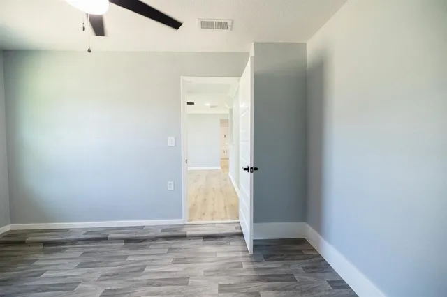 a view of an empty room with wooden floor
