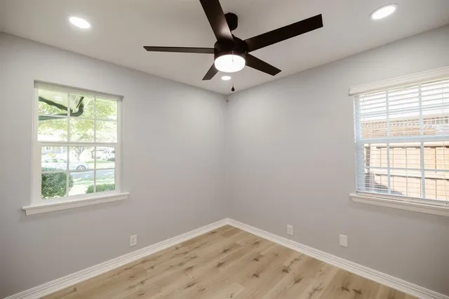 an empty room with a window and a fan