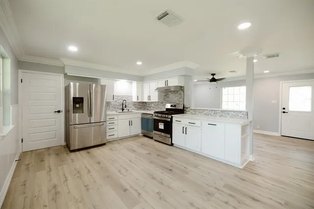 a kitchen with a refrigerator a sink and cabinets