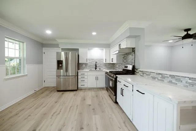 a kitchen with stainless steel appliances a refrigerator sink and cabinets