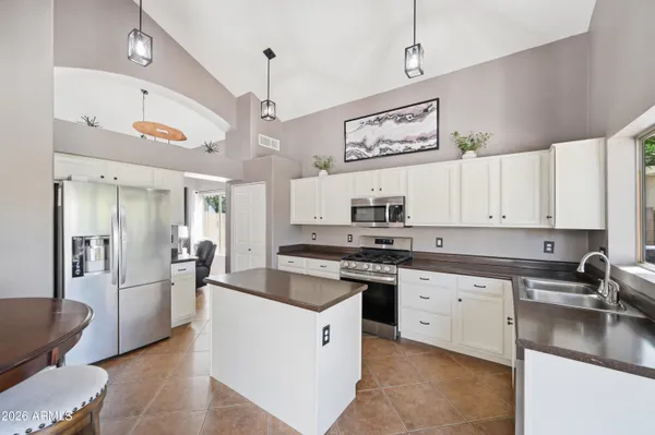 a kitchen with a sink a counter space cabinets and stainless steel appliances