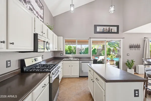 a kitchen with stainless steel appliances granite countertop a sink stove and refrigerator