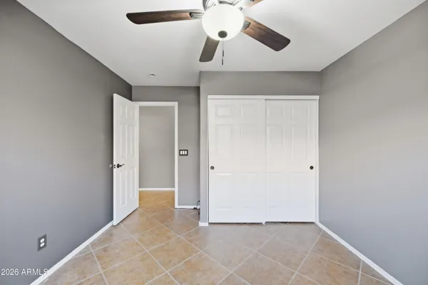 a living room with furniture a flat screen tv and a refrigerator