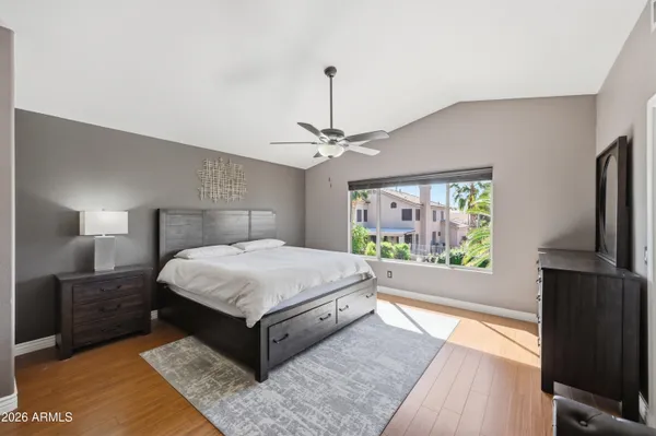 a spacious bedroom with a bed and wooden floor