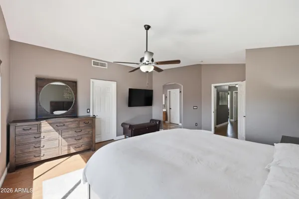 a bedroom with a bed lamp on table and a large window