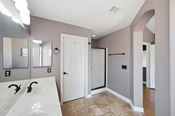 a bathroom with a tub a double vanity sink and a mirror