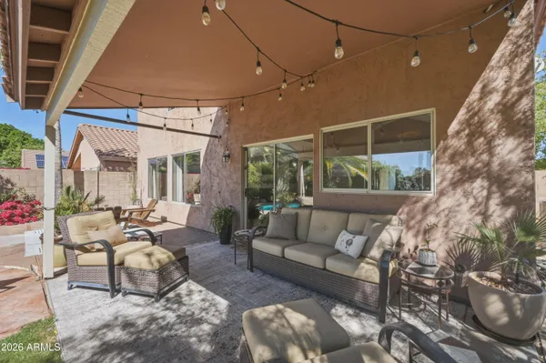 a view of a patio with table and chairs potted plants and palm tree