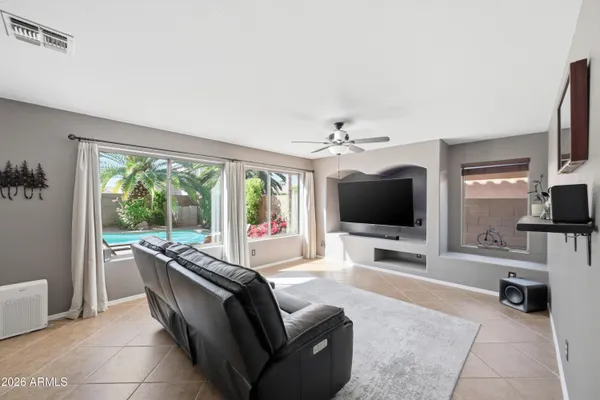 a living room with furniture a chandelier and a flat screen tv