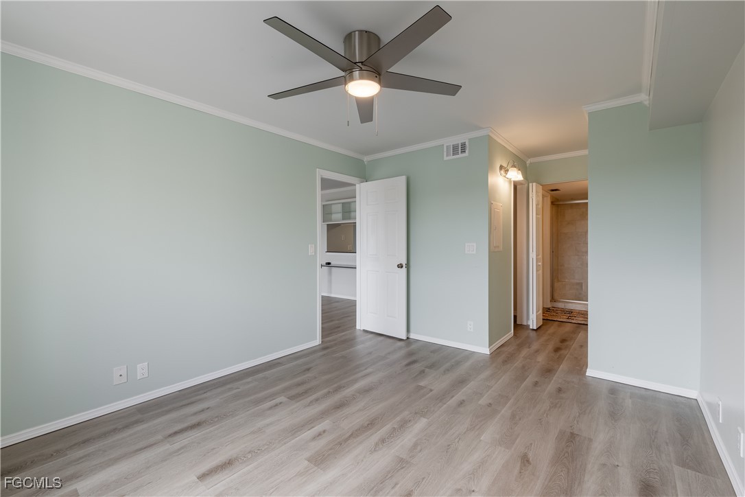 2875 Palm Beach Boulevard, Unit 607 Fort Myers, FL 33916 - Photo 13 of 35 an empty room with wooden floor and ceiling fan