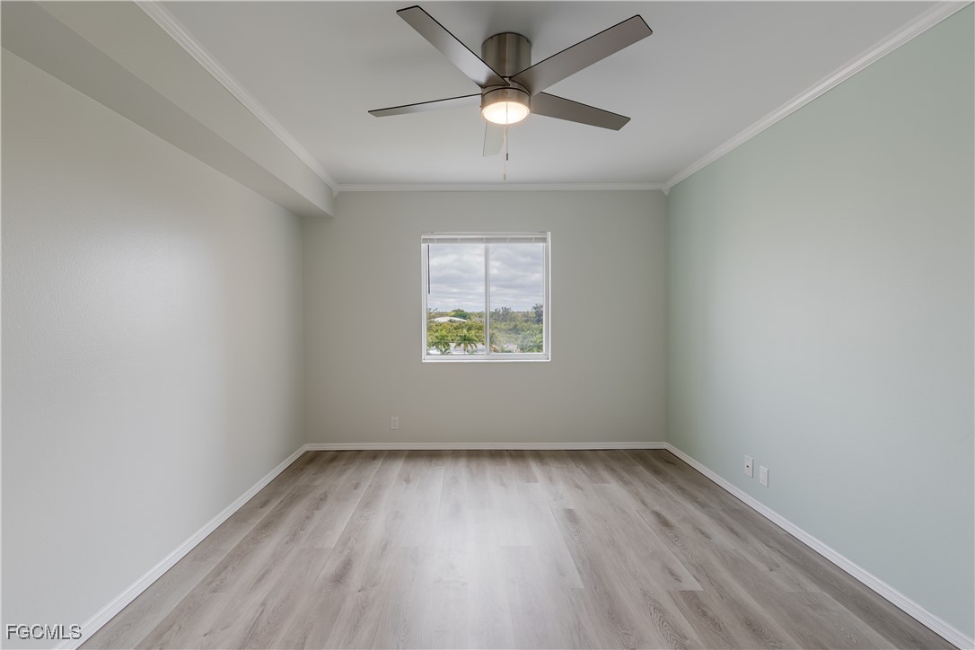 2875 Palm Beach Boulevard, Unit 607 Fort Myers, FL 33916 - Photo 14 of 35 an empty room with wooden floor ceiling fan and windows