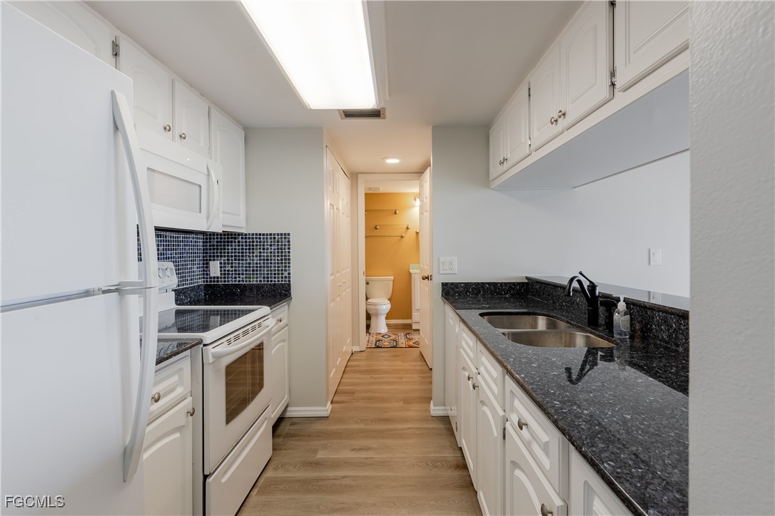 2875 Palm Beach Boulevard, Unit 607 Fort Myers, FL 33916 - Photo 7 of 35 a kitchen with granite countertop a sink and a stove top oven