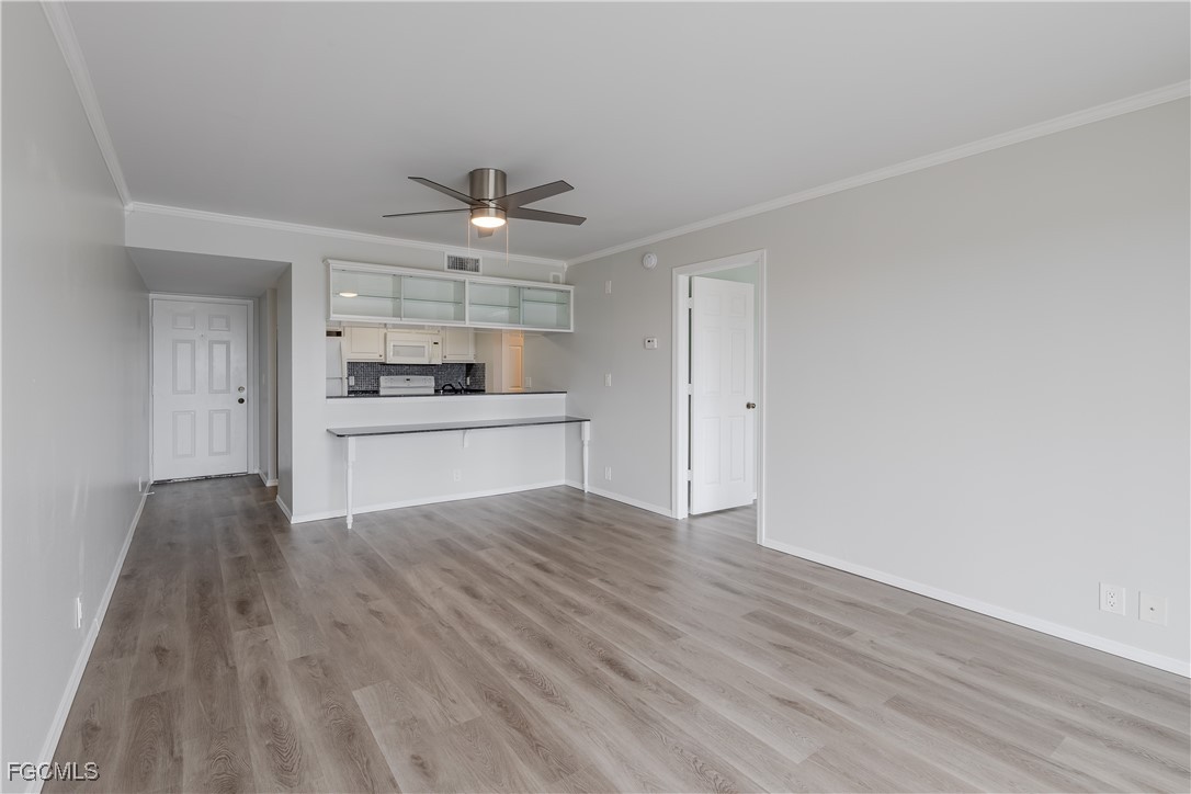 2875 Palm Beach Boulevard, Unit 607 Fort Myers, FL 33916 - Photo 10 of 35 a view of a kitchen with a sink and dishwasher with wooden floor
