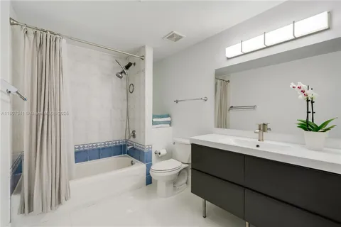 a bathroom with a bathtub a sink and a large mirror