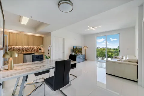 a living room with furniture kitchen view and a large window
