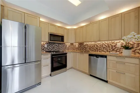 a kitchen with stainless steel appliances granite countertop a refrigerator sink and stove