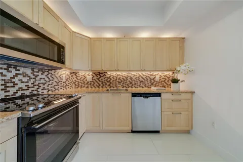 a kitchen with white cabinets and black appliances