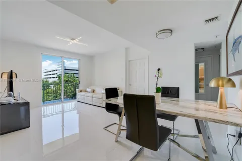 a kitchen with a table chairs refrigerator and cabinets