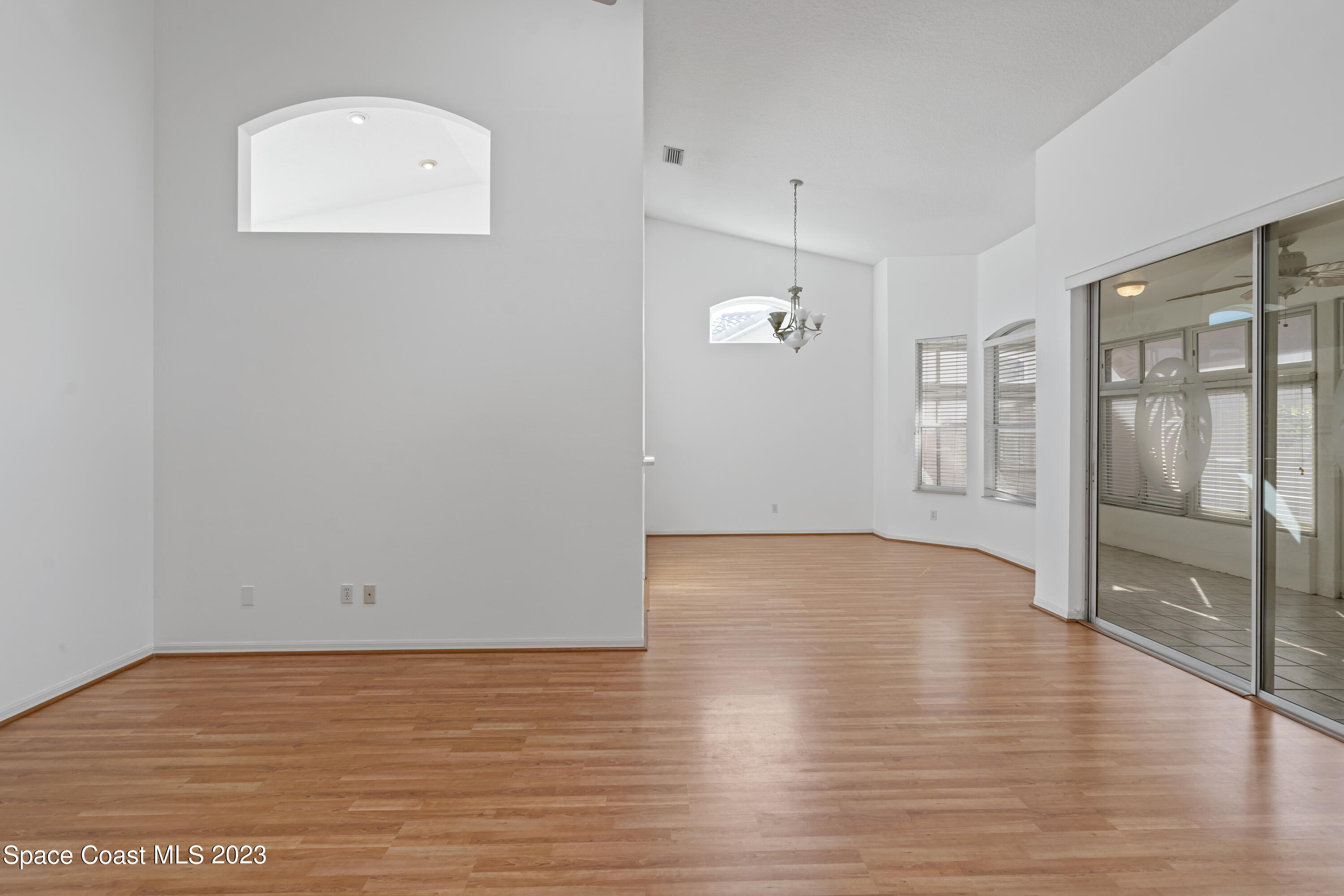 448 Renaissance Avenue Melbourne, FL 32940 - Photo 16 of 57 a view of an empty room with wooden floor and a window