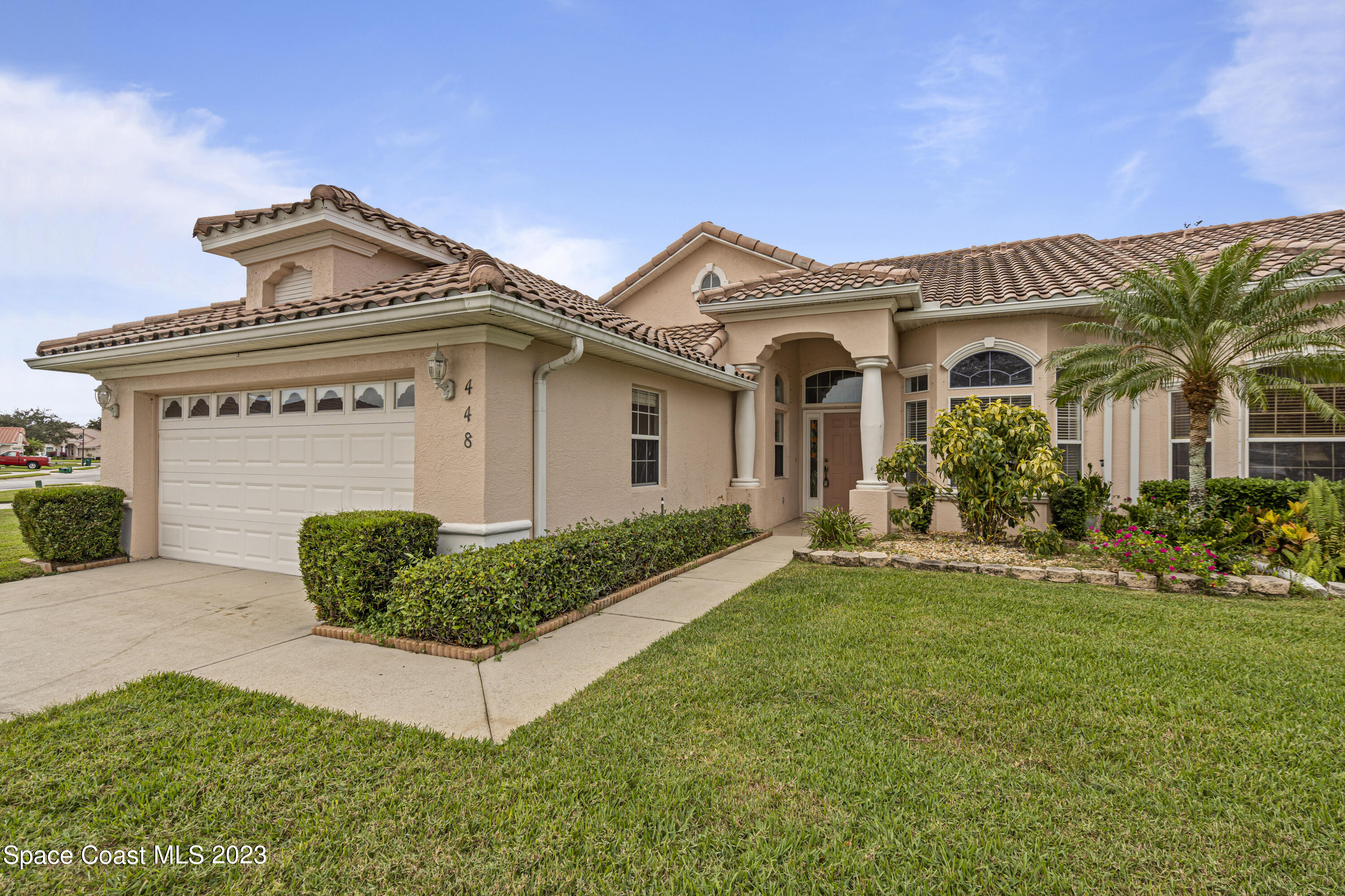 448 Renaissance Avenue Melbourne, FL 32940 - Photo 2 of 57 a front view of a house with a garden