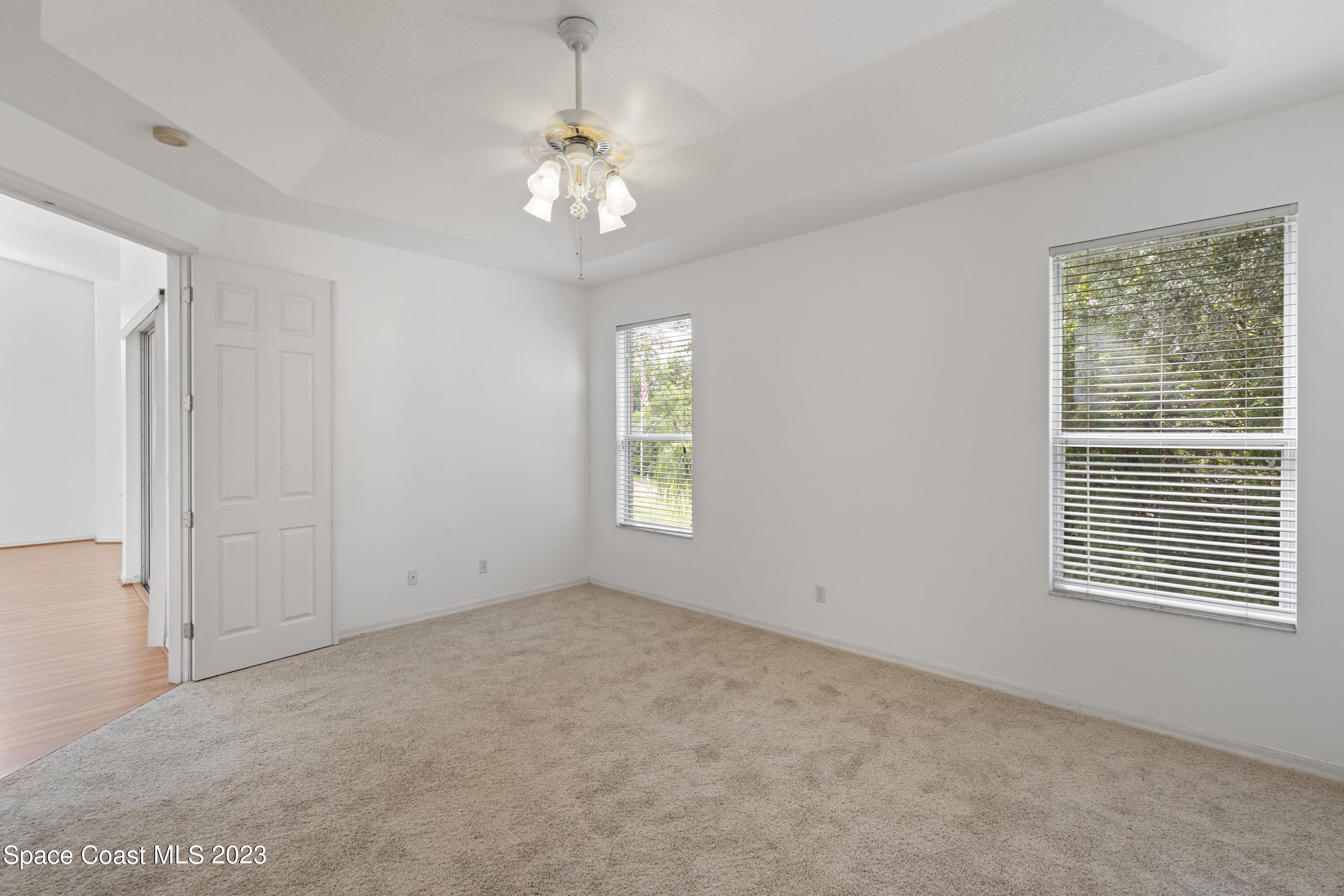 448 Renaissance Avenue Melbourne, FL 32940 - Photo 27 of 57 en empty room with windows and chandelier fan